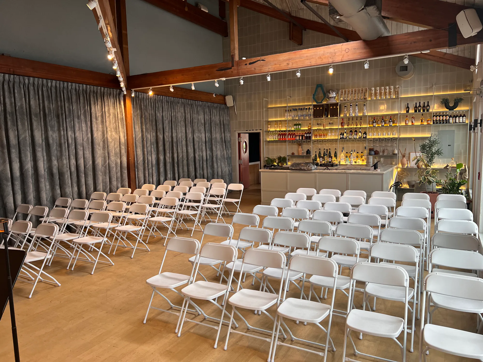 Rows of white chairs arranged by Gather & Go Rentals in an indoor event venue